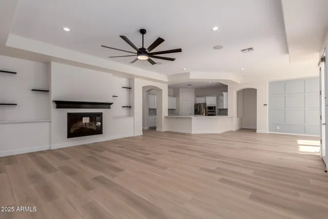 a view of an empty room with window and wooden floor