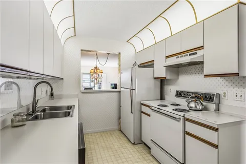 a kitchen with stainless steel appliances granite countertop a sink a stove and refrigerator