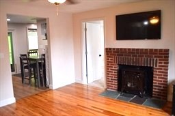 57 Indian Spring Road Ashland, MA 01721 - Photo 8 of 23 a living room with fireplace and a flat screen tv