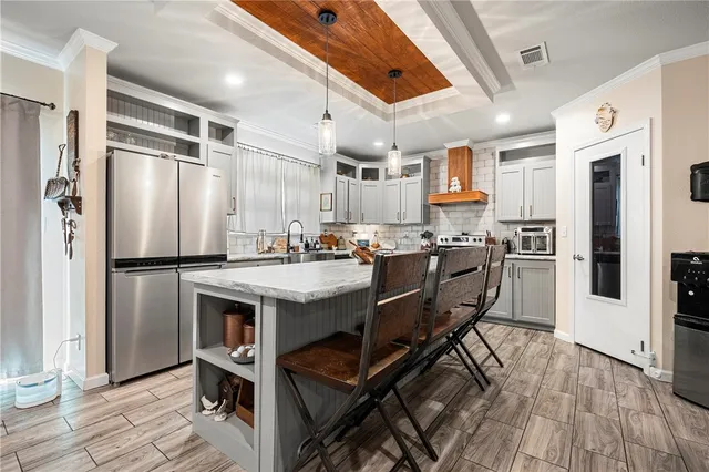 a kitchen with stainless steel appliances granite countertop a stove a sink and a refrigerator