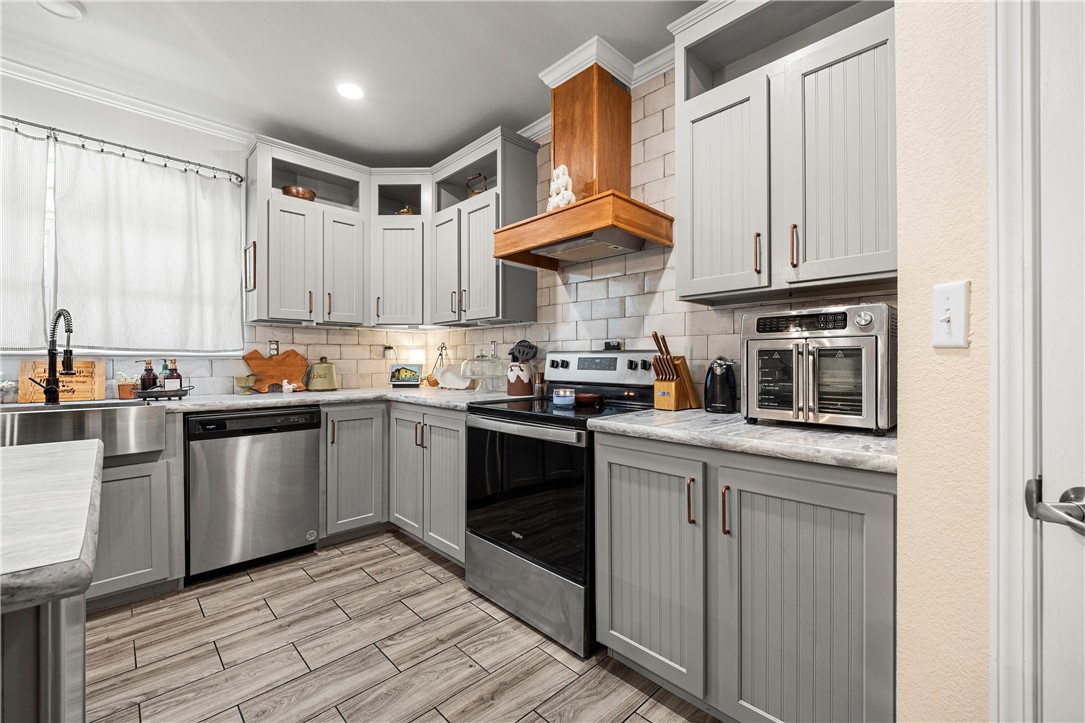 7017 County Road 2253 Odem, TX 78370 - Photo 16 of 40 a kitchen with stainless steel appliances granite countertop a stove a sink and a refrigerator