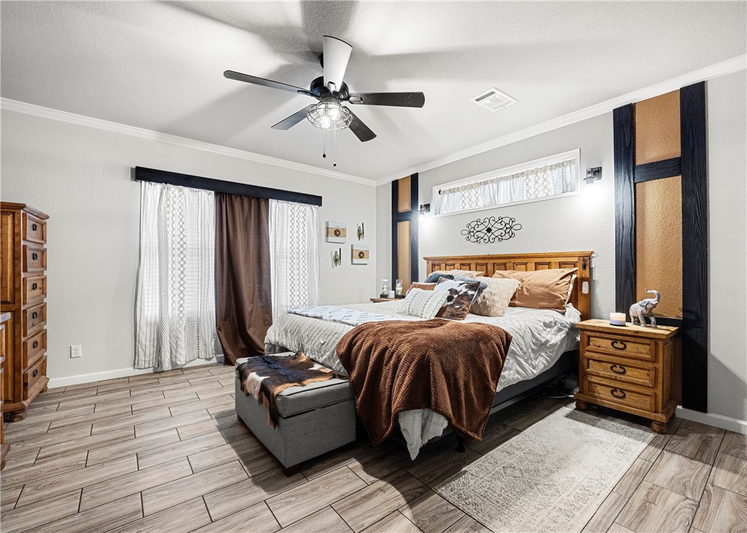 7017 County Road 2253 Odem, TX 78370 - Photo 19 of 40 a bedroom with a bed and a chandelier