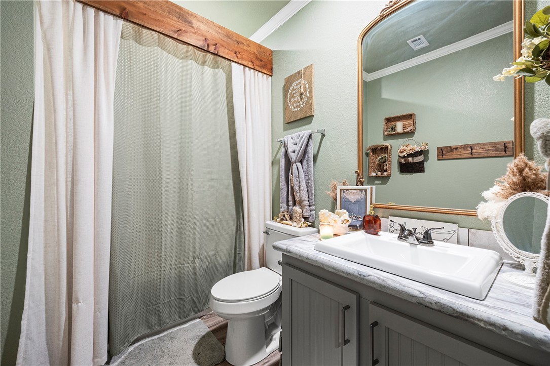 7017 County Road 2253 Odem, TX 78370 - Photo 26 of 40 a bathroom with a sink a toilet and shower curtain