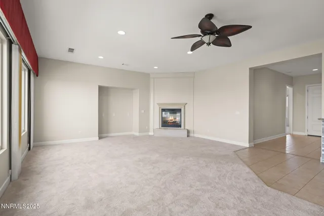 an empty room with fan and windows