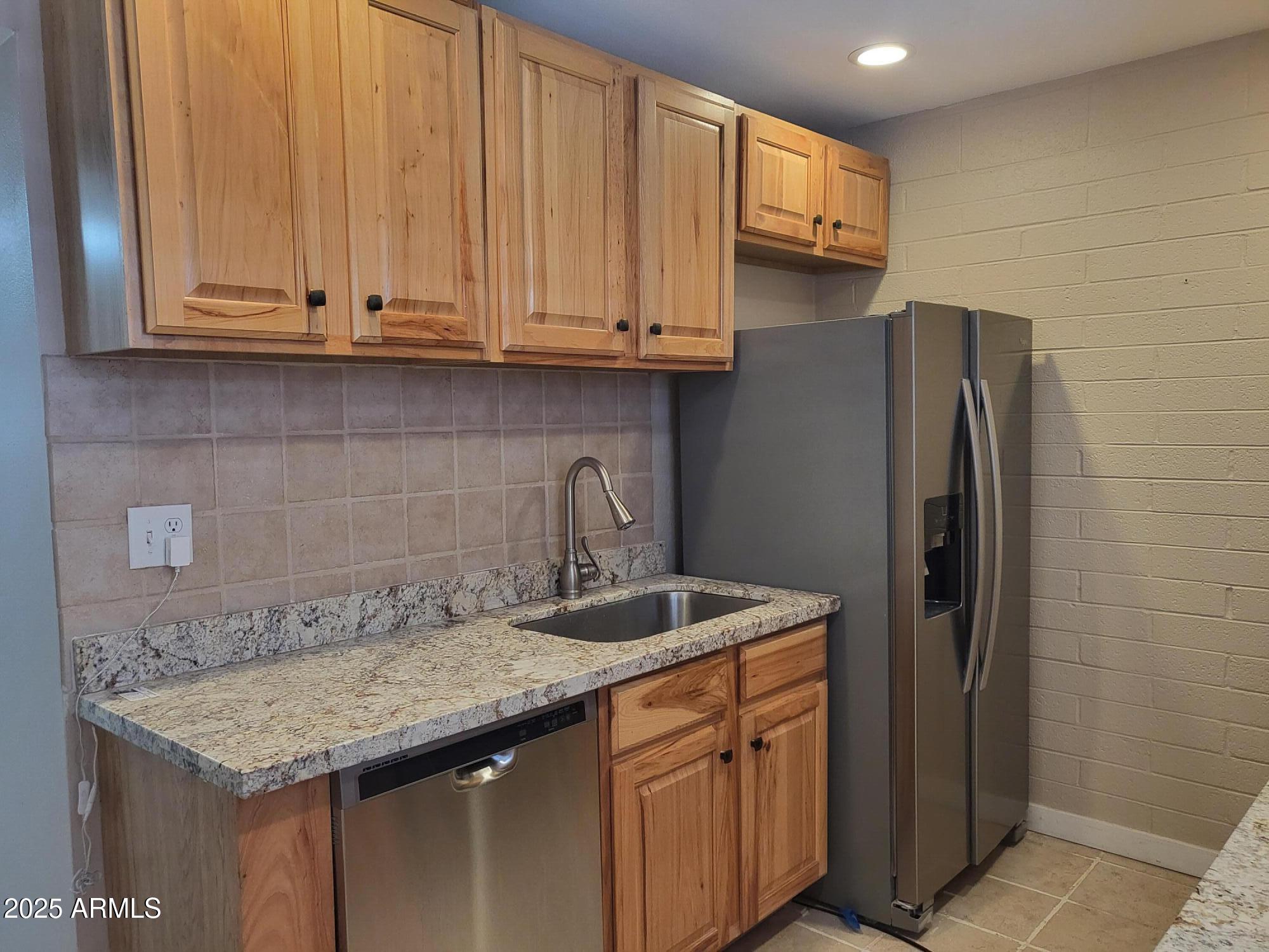 815 North Hayden Road, Unit A204 Scottsdale, AZ 85257 - Photo 8 of 27 a kitchen with stainless steel appliances granite countertop a refrigerator and a sink