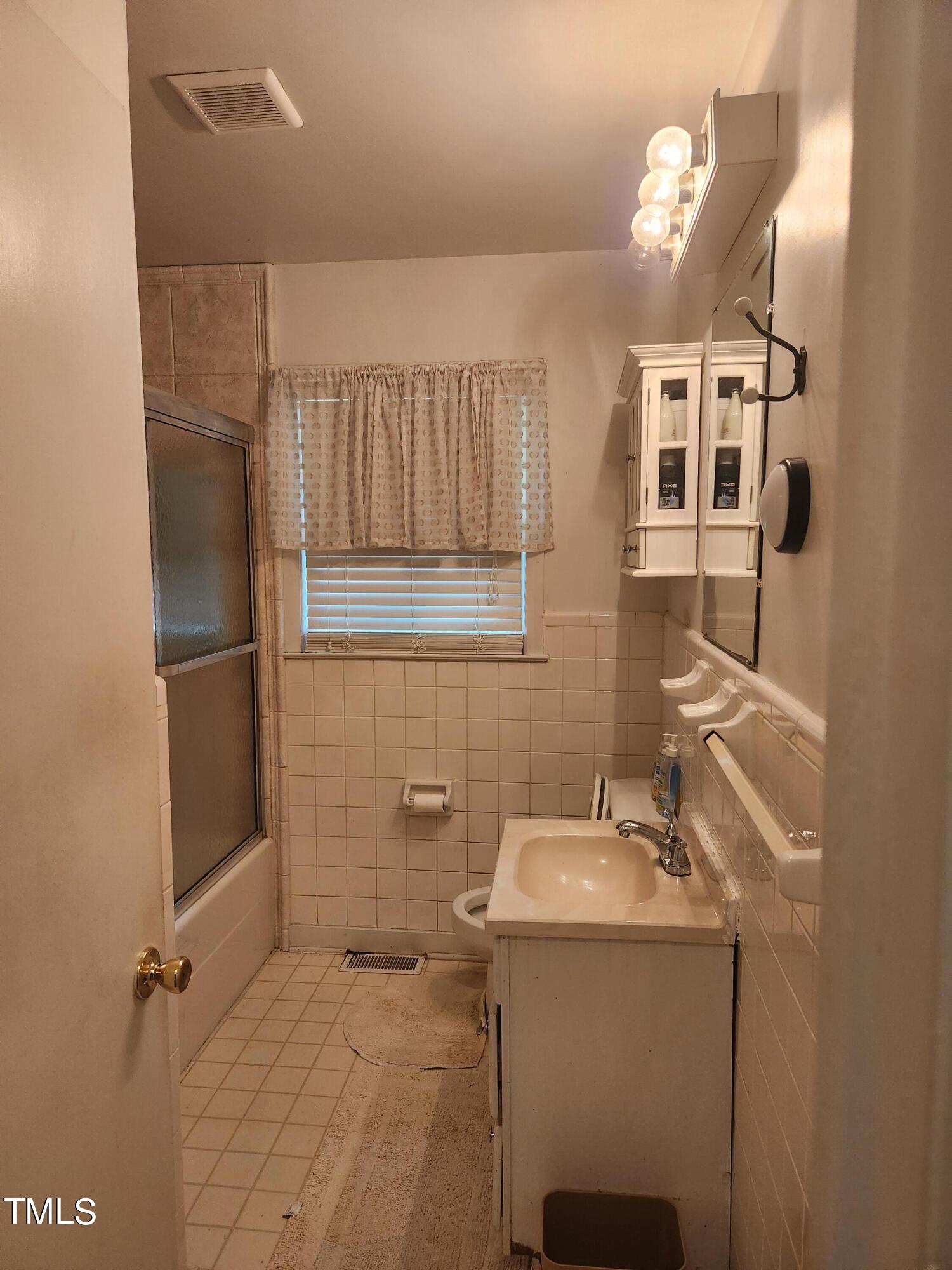 704 Donnelly Road Raleigh, NC 27610 - Photo 13 of 26 a bathroom with a sink a toilet and mirror
