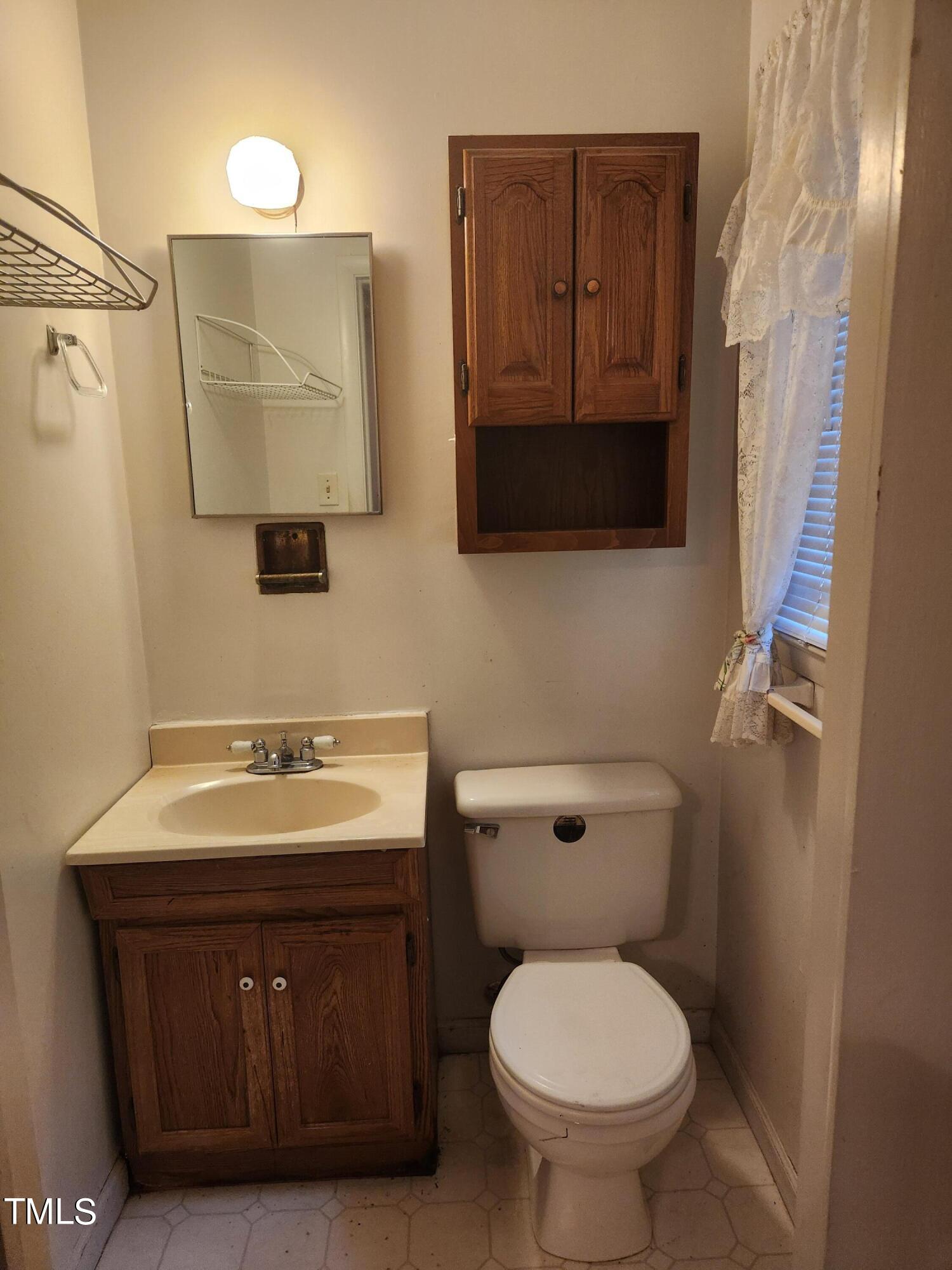 704 Donnelly Road Raleigh, NC 27610 - Photo 16 of 26 a bathroom with a toilet sink and mirror