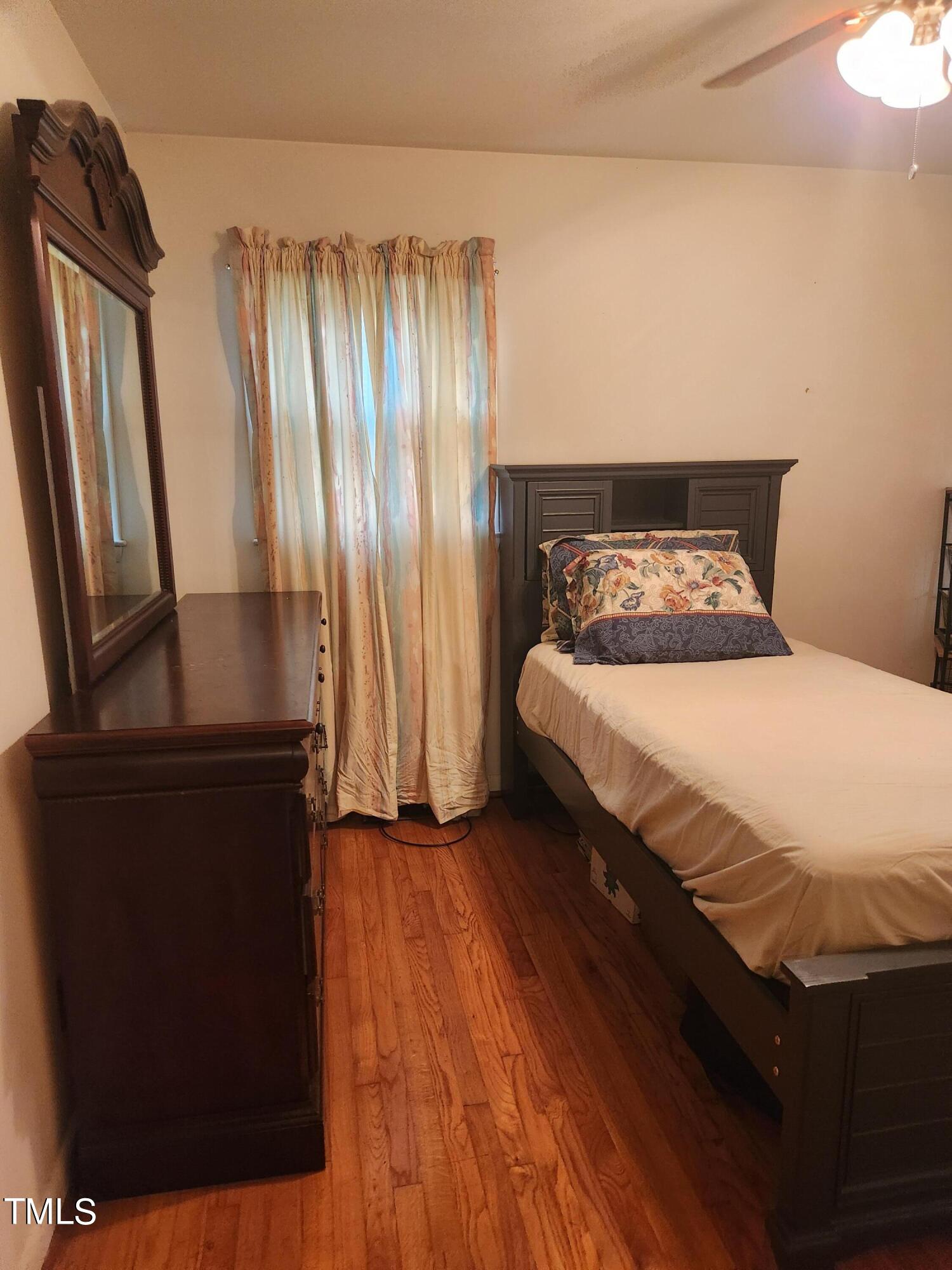 704 Donnelly Road Raleigh, NC 27610 - Photo 17 of 26 a bedroom with a bed and a mirror