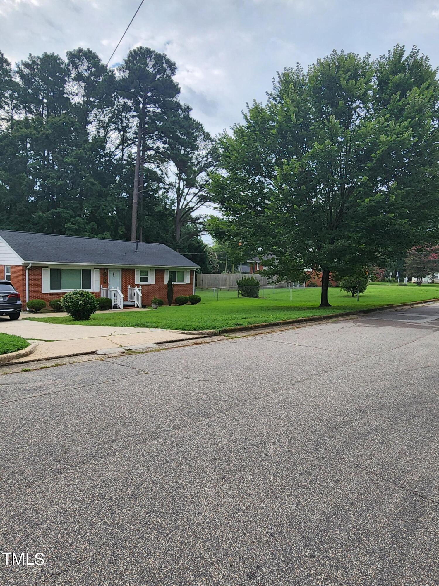704 Donnelly Road Raleigh, NC 27610 - Photo 2 of 26 a yellow house with trees in front of it
