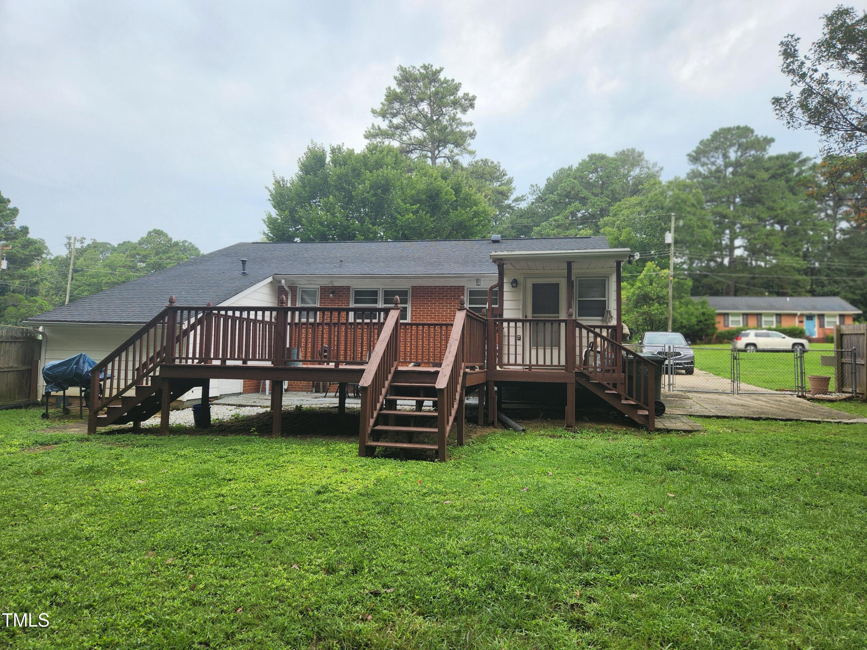 704 Donnelly Road Raleigh, NC 27610 - Photo 25 of 26 a view of a house with a big yard and a wooden deck