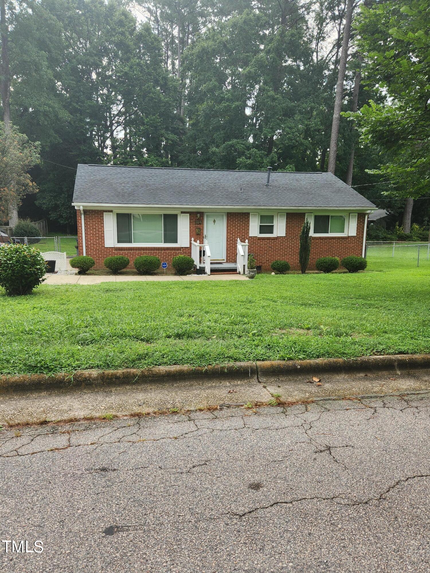 704 Donnelly Road Raleigh, NC 27610 - Photo 3 of 26 a front view of a house with a garden and trees