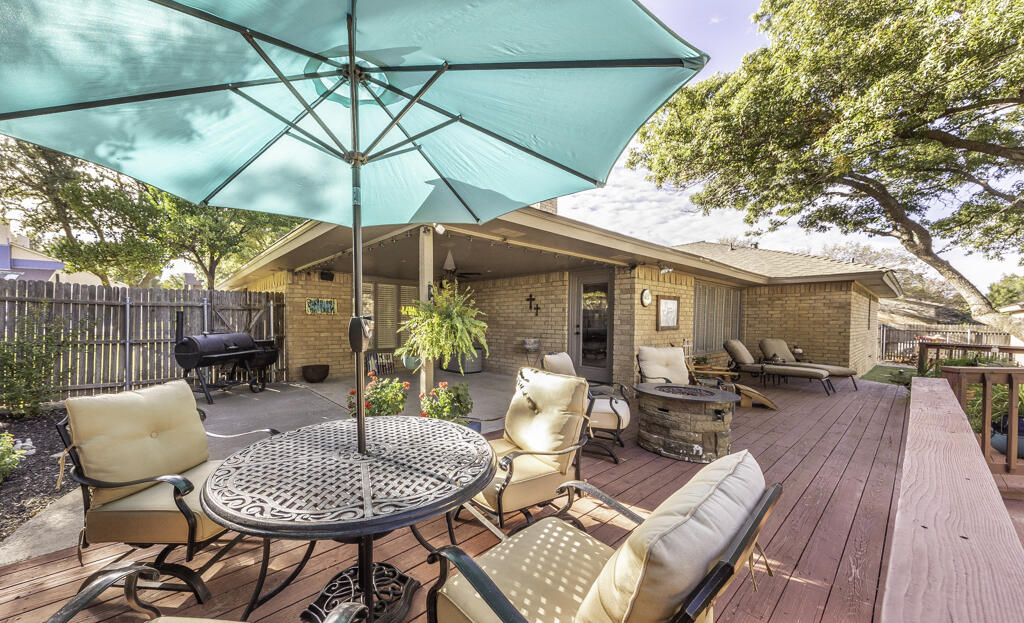 3620 93rd Street Lubbock, TX 79423 - Photo 28 of 33 a view of a patio with a table and chairs under an umbrella