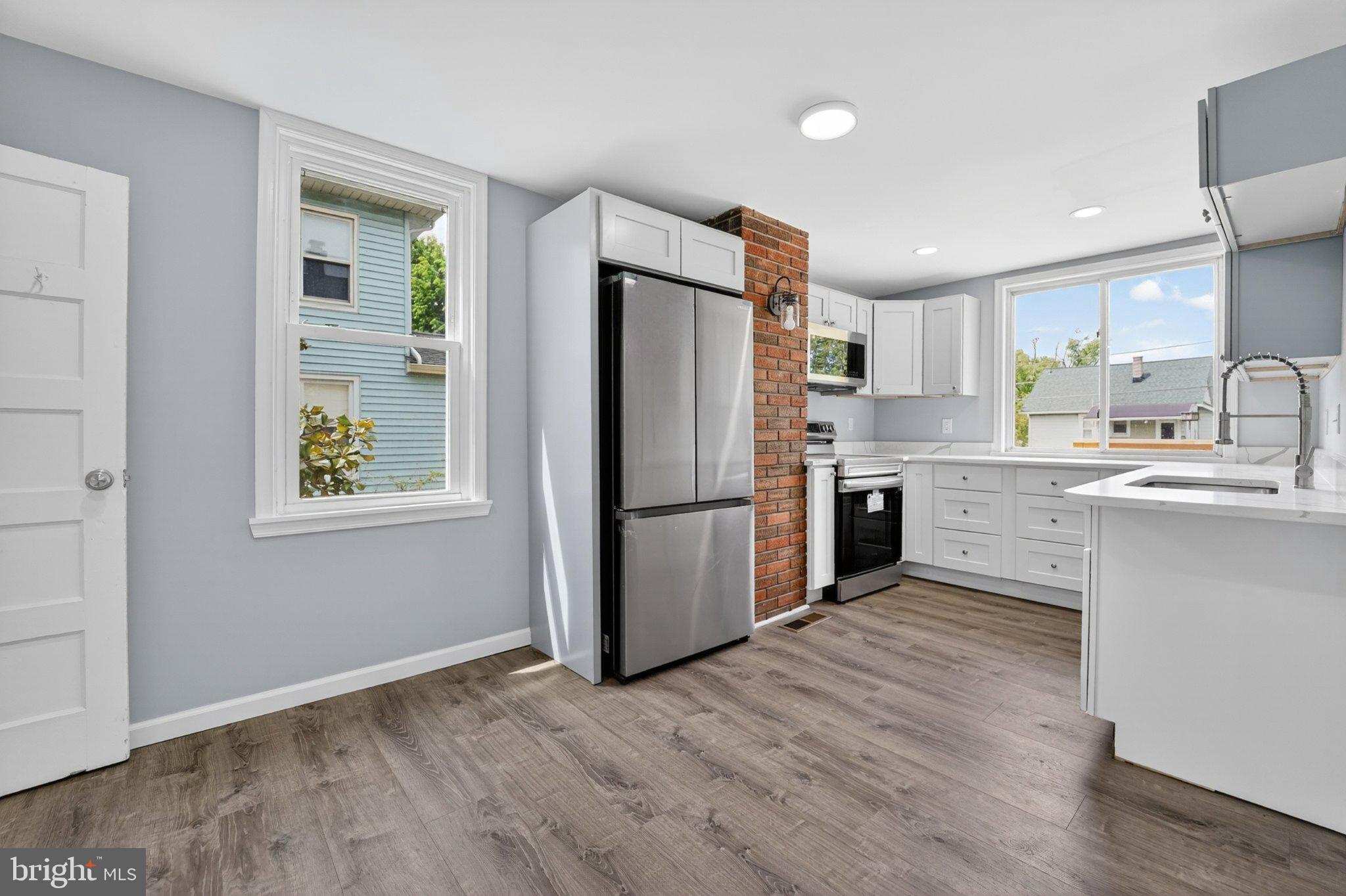 5312 Catalpha Road Baltimore, MD 21214 - Photo 35 of 59 a kitchen with a refrigerator a sink and cabinets