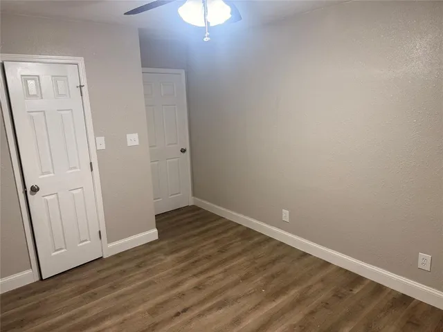 an empty room with wooden floor and door