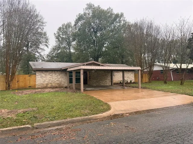 a front view of a house with a garden and trees