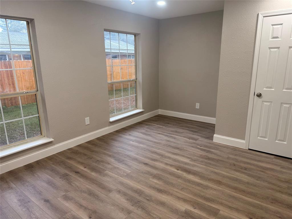 112 Myrtle Drive New Boston, TX 75570 - Photo 7 of 31 an empty room with wooden floor and windows