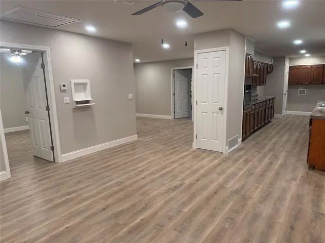 a large white kitchen with cabinets a sink and appliances