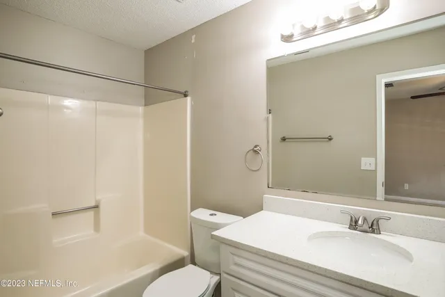 an empty room with closet and a ceiling fan