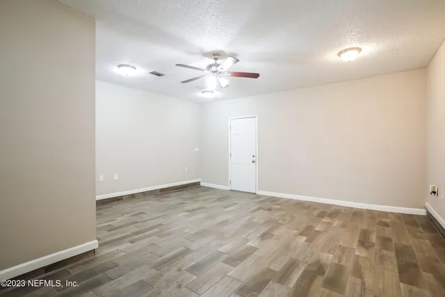 an empty room with fan and windows
