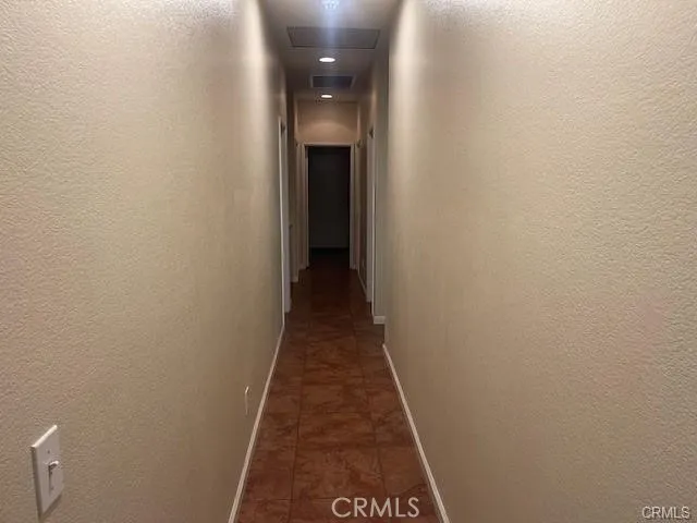 a view of a hallway with wooden floor and a bathroom