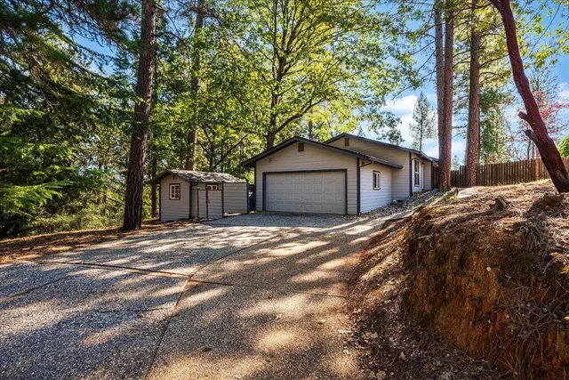 a view of a house with a yard and large tree