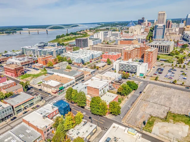 a view of a brick house with many windows and a tree