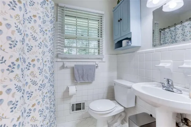 a bathroom with a sink a toilet and a mirror