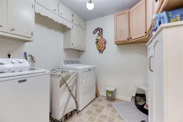 a utility room with cabinets washer and dryer
