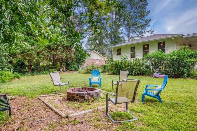 a backyard of a house with plants and large trees