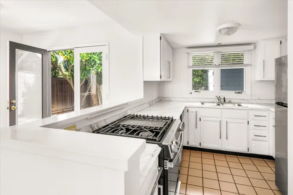 a kitchen with a stove a sink and a window