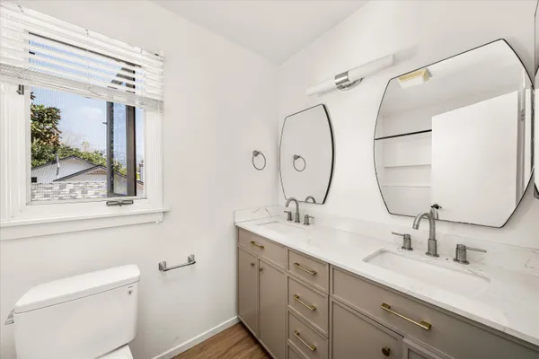 a bathroom with a double vanity sink mirror and toilet