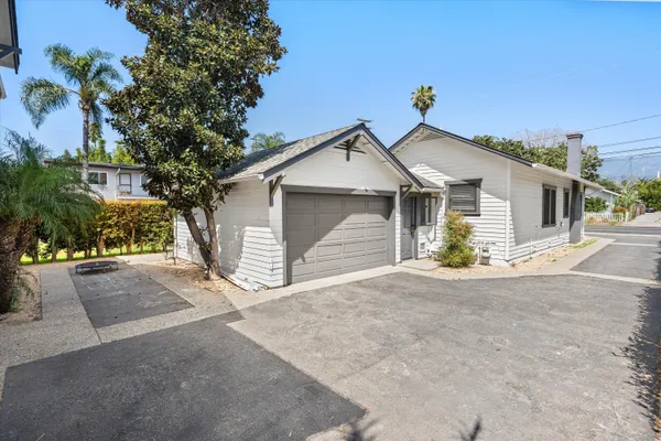 a view of a house with a yard and large tree