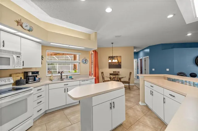 a large white kitchen with cabinets and sink