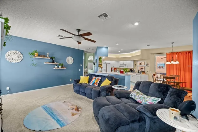 a living room with furniture and kitchen view