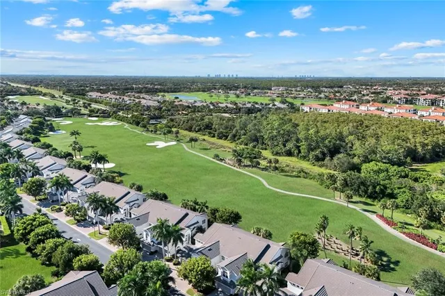 an aerial view of a city with lots of residential buildings and mountain view in back
