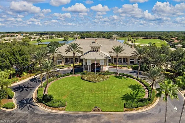 a front view of a house with a yard and palm trees
