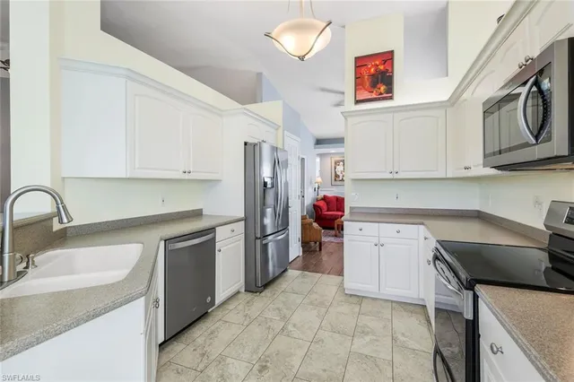 a kitchen with a sink stove top oven and cabinets