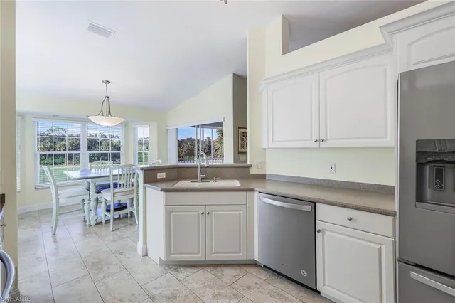 a kitchen with a sink and chairs