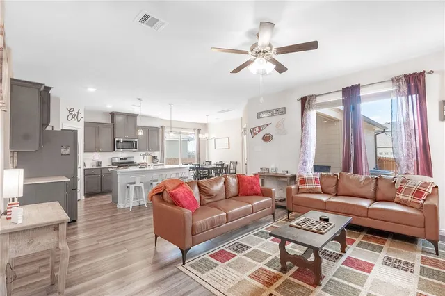 a living room with furniture ceiling fan and a rug
