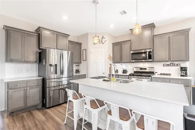a kitchen with stainless steel appliances a stove a sink a refrigerator and cabinets