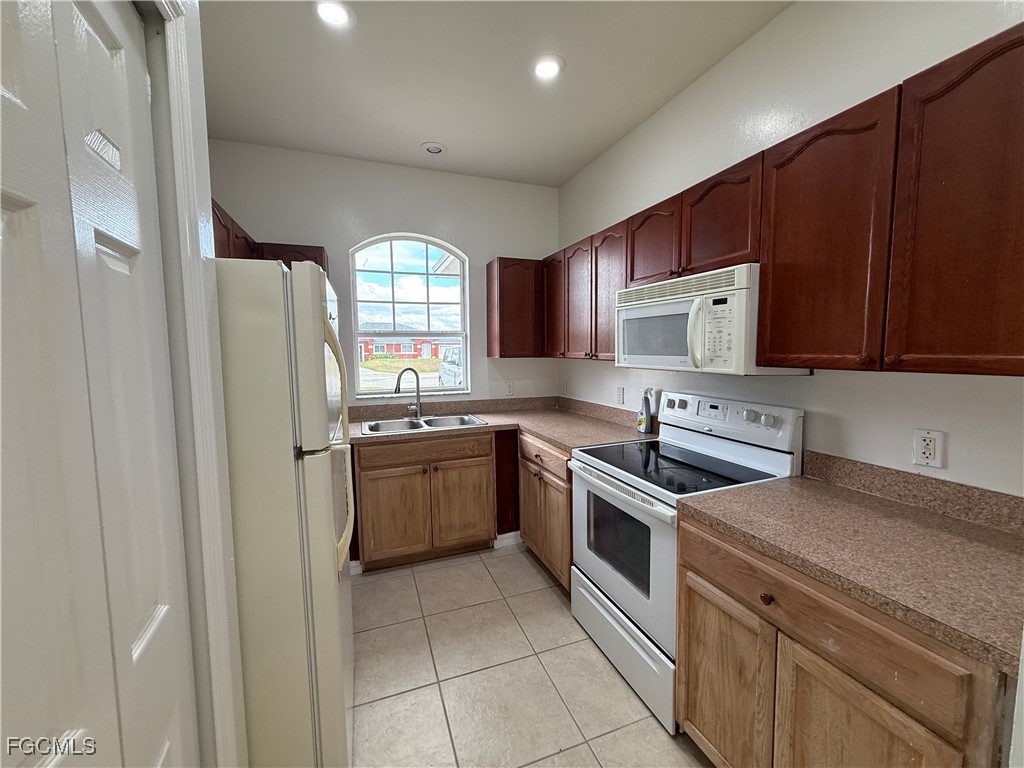 3969 Sunset Road Lehigh Acres, FL 33971 - Photo 14 of 29 a kitchen with a sink a stove and cabinets