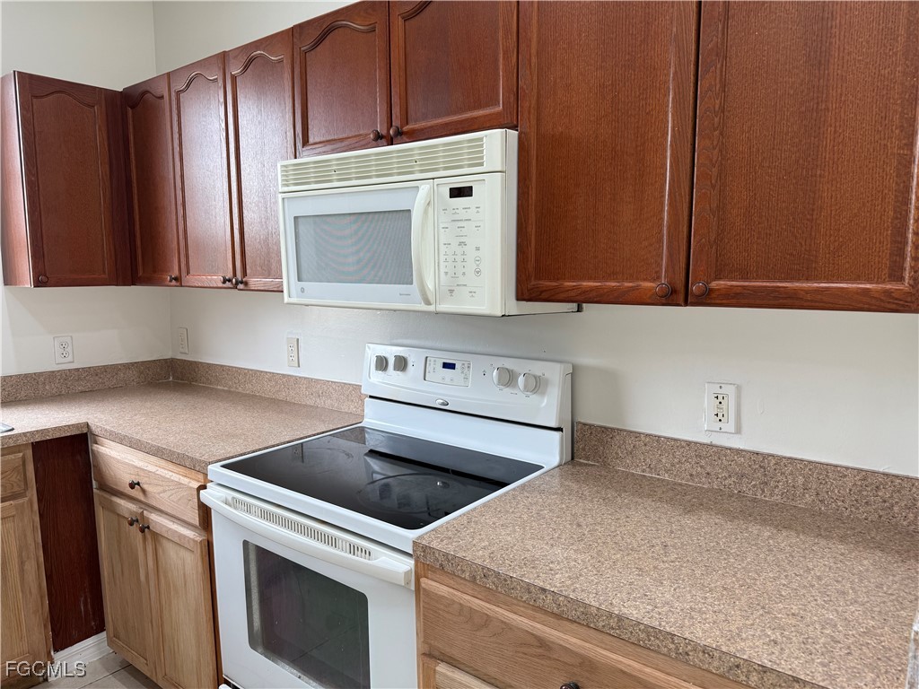 3969 Sunset Road Lehigh Acres, FL 33971 - Photo 16 of 29 a kitchen with granite countertop cabinets appliances and a counter top
