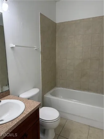 a bathroom with a granite countertop toilet and a sink