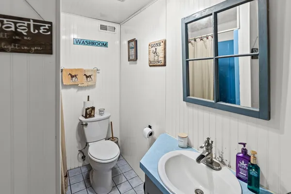 a bedroom with a bed a chair and a flat screen tv