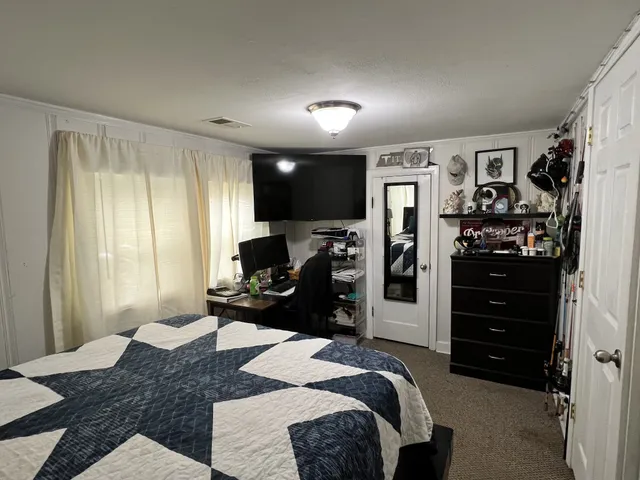 a bedroom with a bed and a television