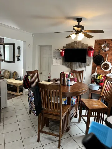 a living room with furniture a flat screen tv and a chandelier