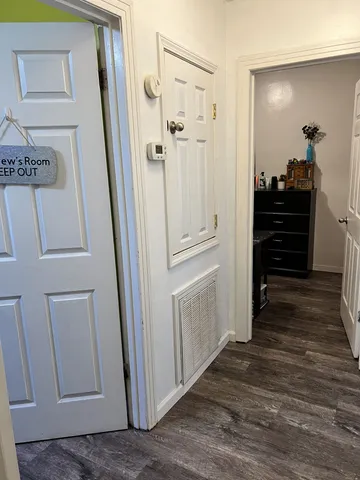 a view of a hallway with wooden floor and staircase