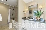 a bathroom with a granite countertop sink a mirror and shower