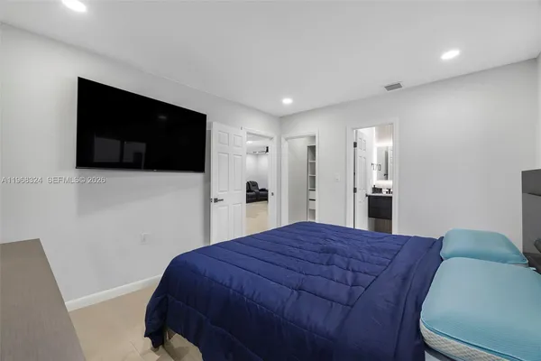 a large bedroom with a bed and a flat screen tv