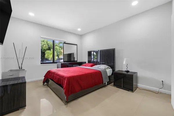 a spacious bedroom with a bed and window